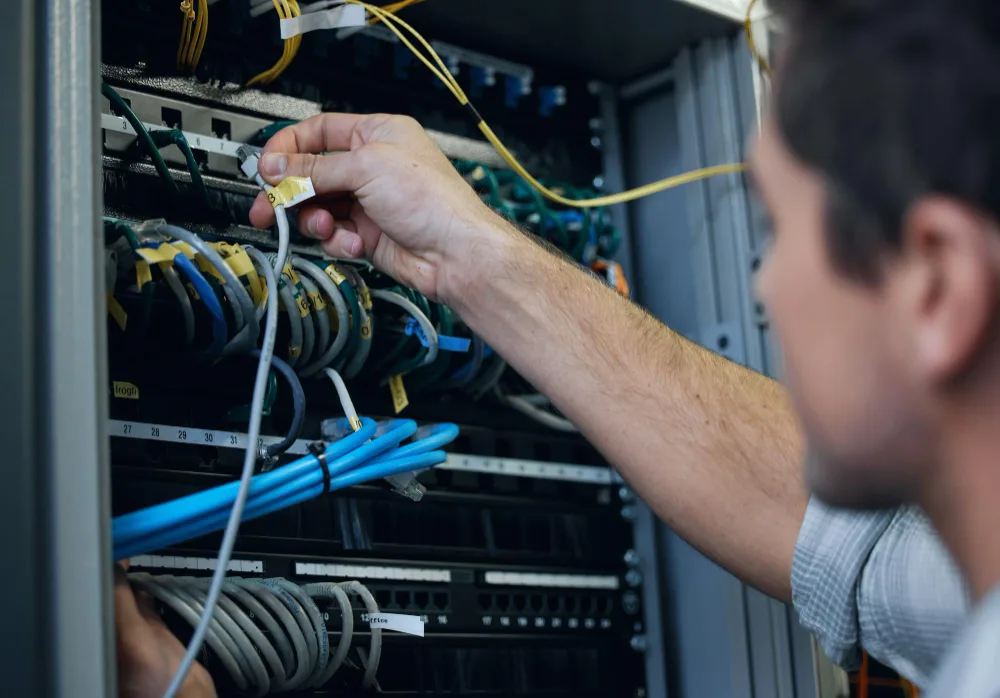 Technician working with network infrastructure in a server room