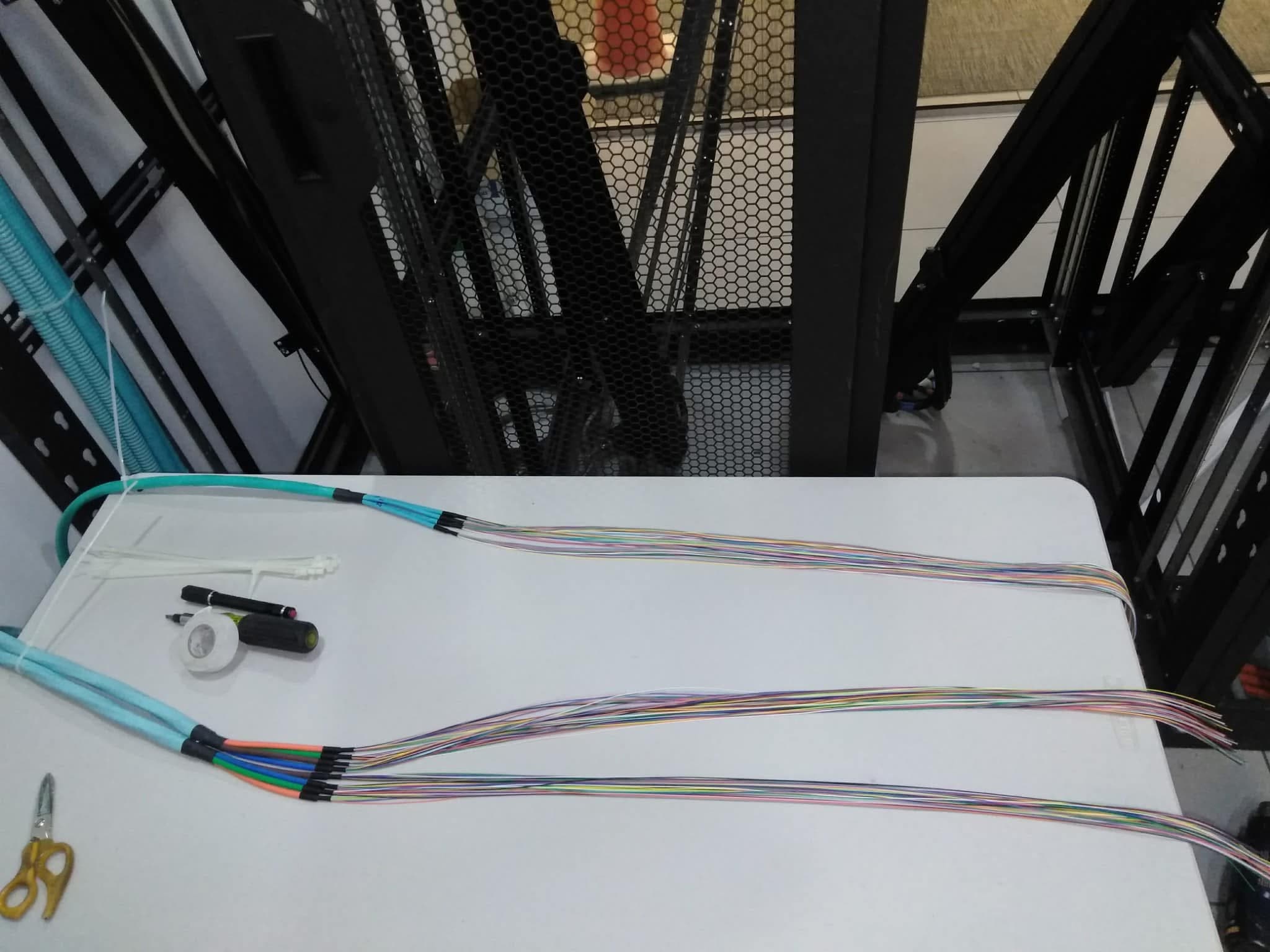 Fiber optic cable fanout with color-coded strands prepared on a worktable