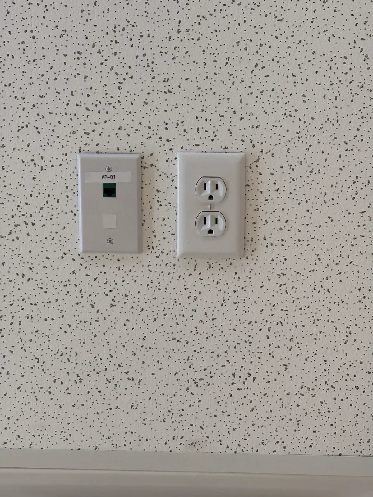 Labeled network faceplate installed next to a power outlet